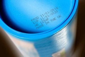 Blue industrial container with manufacturing date and expiration details.